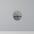 Oval konsthylla i svart finish, betongvägg